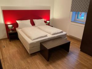 a bedroom with a large bed with a red headboard at Gästehaus Linde Salching in Salching