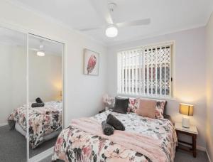1 Schlafzimmer mit 2 Betten und einem Spiegel in der Unterkunft Guest House On Guy in Forster