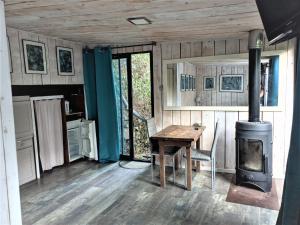eine Küche mit einem Tisch und einem Holzofen in der Unterkunft Chalet dans Résidence Privée in La Gaude