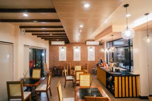 a restaurant with tables and chairs and a bar at Marieli Suites near Panglao International Airport in Panglao Island
