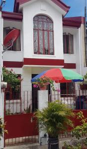 een wit en rood huis met een kleurrijke paraplu bij 2-storey house san pedro laguna belinda condotel 3 in San Pedro