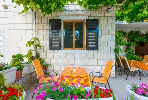 a patio with a table and chairs and flowers at Villa Kukuljica in Zaton