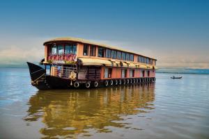 a house boat sitting on the water in the water at JCT Houseboat in Alleppey