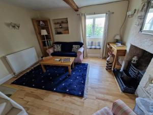 a living room with a couch and a table at Half-pint Cottage in Stroud