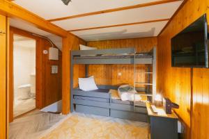 a bedroom with a bunk bed and a bathroom at The Farmhouse in Sedrun