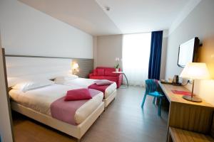 a hotel room with two beds and a desk and a desk at Hotel Mercure Venezia-Marghera in Marghera +50 photos