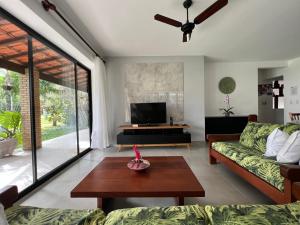 a living room with a couch and a table at Casa Vivá Guaeca in São Sebastião