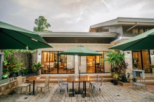 a table with chairs and an umbrella in front of a building at Marieli Suites near Panglao International Airport in Panglao Island