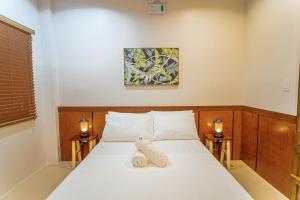 a bedroom with a bed with a towel on it at Marieli Suites near Panglao International Airport in Panglao Island +38 photos