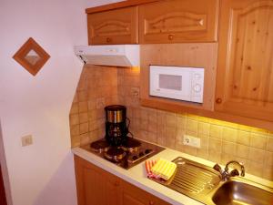 a kitchen with a stove and a microwave at Haus Hoher Sattel in Leutasch +50 photos