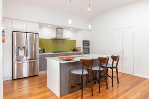 a kitchen with a counter with chairs and a refrigerator at Seaclusion in Elizabeth Beach