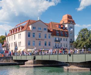 Un gruppo di persone che camminano su un ponte sopra un fiume di Hotel Am Alten Strom a Warnemünde