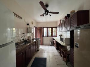 a large kitchen with a ceiling fan in a room at Casa Vivá Guaeca in São Sebastião