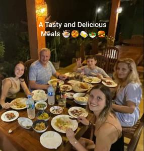 um grupo de pessoas sentadas à volta de uma mesa a comer em Oleena Home Stay em Habarana