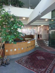 un vestíbulo con un gran árbol en un edificio en Hotel Goldener Stern, en Sankt Ingbert