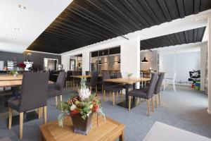 a dining room with tables and chairs and flowers on tables at Le Petit Relais in Gstaad