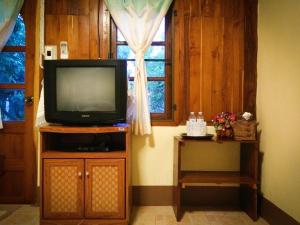 TV en un stand en una habitación con ventana en Sangsawang Resort, en Mae Hong Son