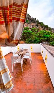 einen Balkon mit einem Tisch und Stühlen sowie Aussicht in der Unterkunft Grazalema- Casita Panorama - Fantastic views- Clima & Wi-Fi in Grazalema