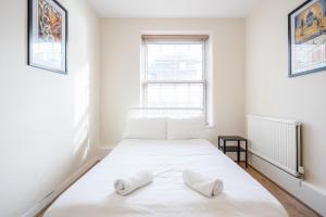 um quarto com uma cama branca com duas almofadas em APlaceToStay Central London Apartment, Zone 1 KIN em Londres
