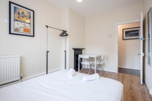 um quarto com uma cama branca e uma secretária em APlaceToStay Central London Apartment, Zone 1 KIN em Londres