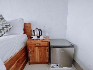 Zimmer mit einem Bett und einem kleinen Tisch mit einem Kühlschrank in der Unterkunft Aurora Beach View in Nusa Lembongan