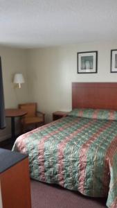 a hotel room with a bed and a table at Royal Inn Motel in Watertown
