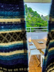 einem gestreiften Pullover auf einem Balkon mit einem Tisch und einer Bank in der Unterkunft Grazalema - Casita La Calma - Increíbles vistas, Climatización Frio-Calor, Wifi, Parking in Grazalema