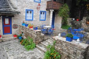 a brick house with blue doors and a table and chairs at Orestis House in Ano Pedina