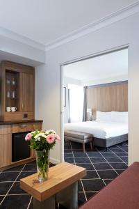 a hotel room with a bed and a vase of flowers on a table at Holiday Inn Darling Harbour, an IHG Hotel in Sydney