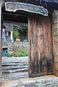 a wooden door with a sign that reads to enter you operating at Orestis House in Ano Pedina