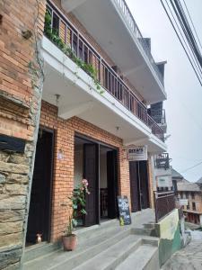 a brick building with a balcony on top of it at Diya's Guest House in Bandipur