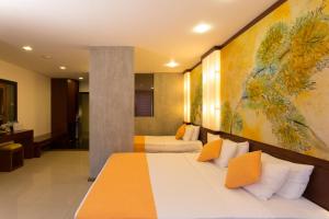 una camera d'albergo con due letti e un dipinto sul muro di Hotel Topaz a Kandy