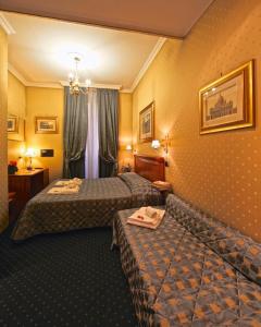 Habitación de hotel con 2 camas y sofá en Vatican Holiday en Roma