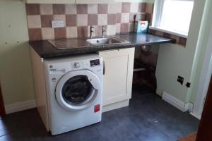 a kitchen with a washing machine and a sink at Porthcawl House Near Beach With Extensive Parking in Porthcawl