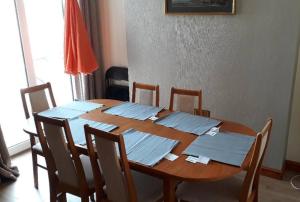 a wooden dining room table with chairs and papers on it at Porthcawl House Near Beach With Extensive Parking in Porthcawl