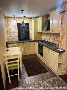 a kitchen with a table and a stove top oven at Apartament De Lux zona 0 Botosani 2 camere in Botoşani
