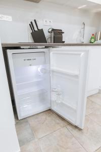 a white refrigerator with its door open in a kitchen at Your Cozy Sapphire Apartment in Athens