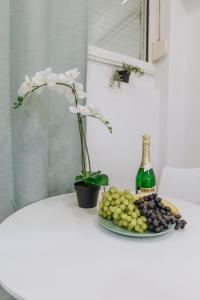 a table with a plate of grapes and a bottle of wine at Your Cozy Sapphire Apartment in Athens