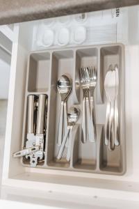 a drawer filled with silver utensils in a kitchen at Your Cozy Sapphire Apartment in Athens