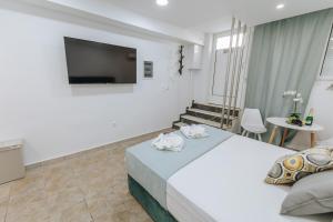 a hotel room with a bed and a flat screen tv at Your Cozy Sapphire Apartment in Athens