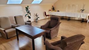 a waiting room with chairs and a table and a table and a table at Delmajk in Mała Nieszawka