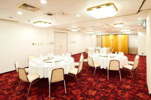 una sala de conferencias con mesas y sillas blancas en Marroad Inn Tokyo, en Fuchu