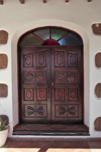 a large wooden door in a wall with a window at Casa Palmeral in Mácher