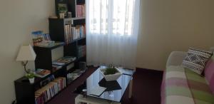 Chambres d'hôtes Les Lavandes Rocamadour في روكامادور: غرفة مع رف كتاب مع نبات على طاولة
