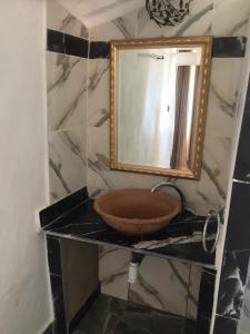 uma casa de banho com um lavatório e um espelho em Palais d'hôtes em Salé