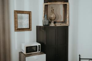 a microwave sitting on top of a refrigerator next to a cabinet at Urbino Casa in Cluj-Napoca