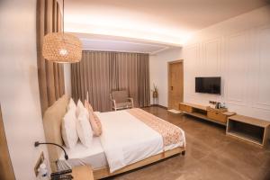 Hotel Mirana , Tinsukia في Tinsukia: غرفه فندقيه سرير وتلفزيون