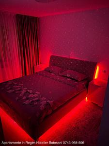 een slaapkamer met een bed met een rood licht bij Apartament cu 3 camere De Lux aproape de Cornisa Aquapark vizavi de Carrefour in Botoşani