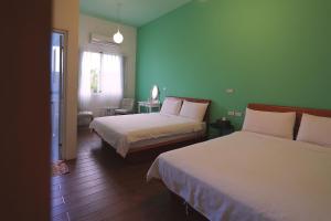 En eller flere senge i et værelse på Taitung city-cottage B&B