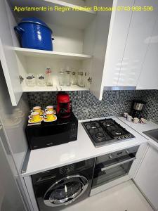 een keuken met een fornuis en een magnetron bij Apartament cu 3 camere De Lux aproape de Cornisa Aquapark vizavi de Carrefour in Botoşani